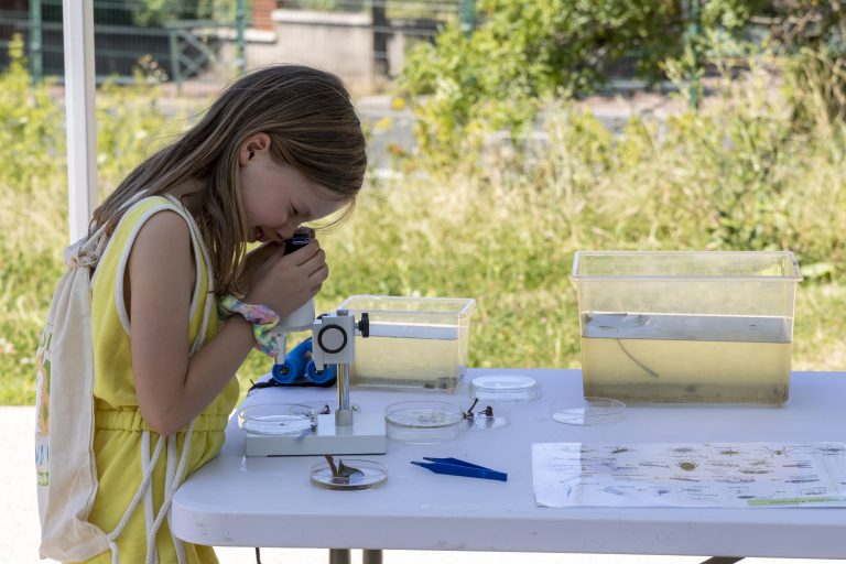Enfant découvrant l'eau avec un microscope