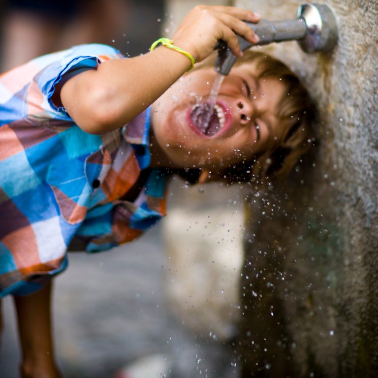 Enfant se désaltérant à une fontaine